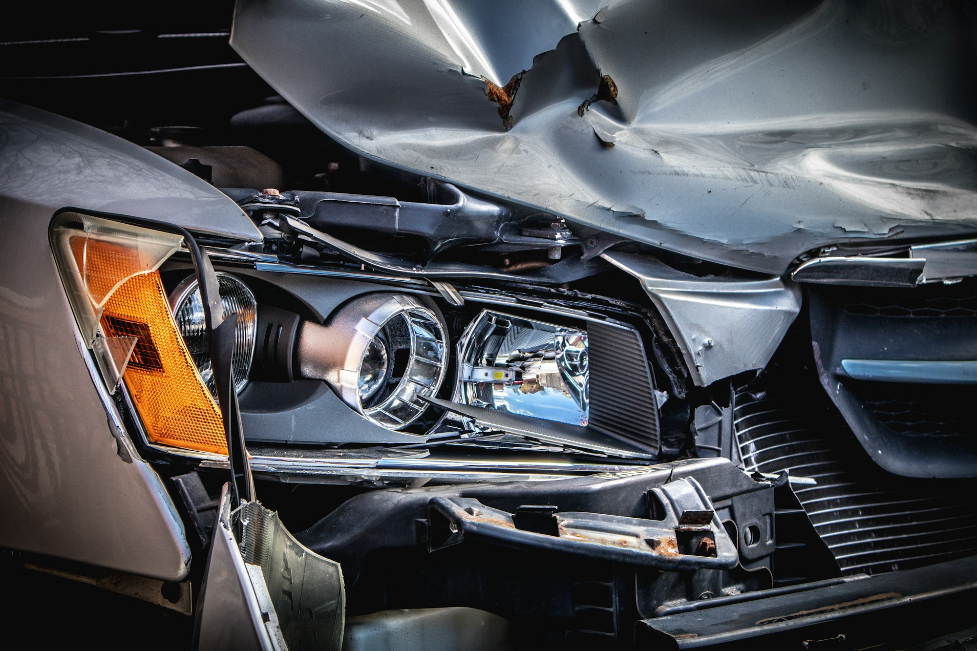 A car with a crushed bonnet and broken headlamp after a collision
