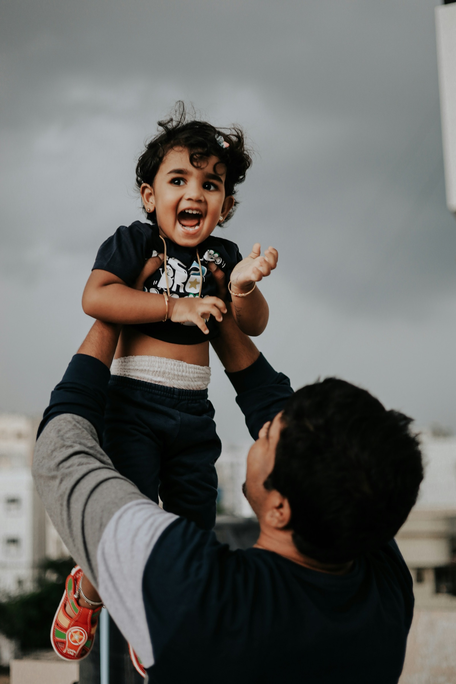 A father lifting his young child into the air