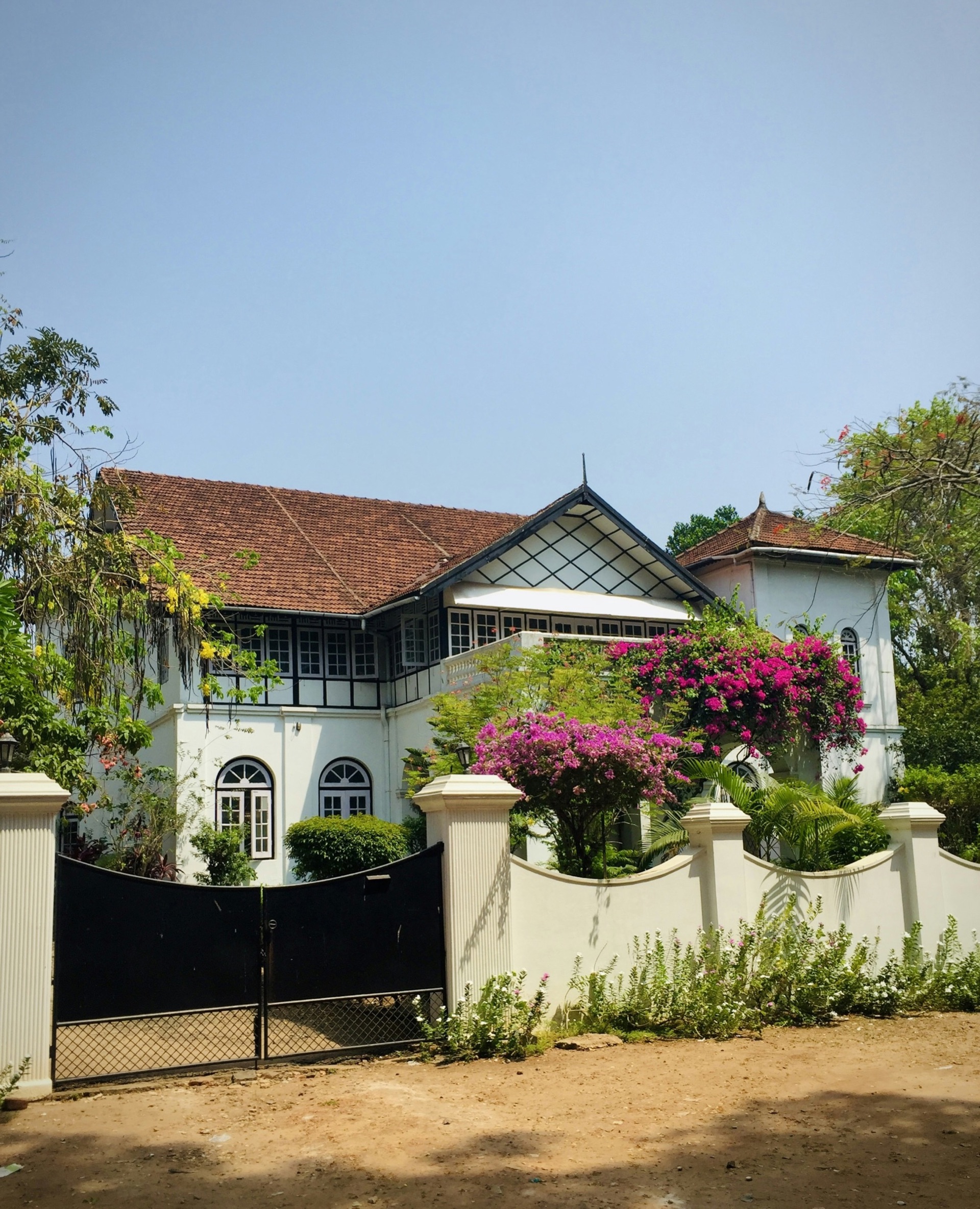 A white house with a black gate and garden