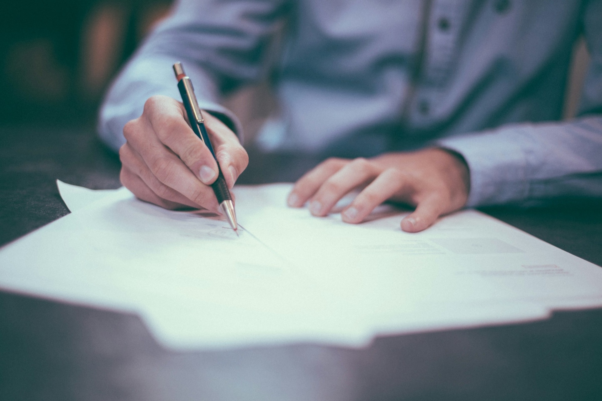 A hand writing notes on a document